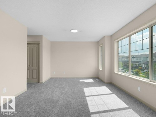 Spacious room with plush gray carpeting, large multipane windows, and recessed ceiling lighting - 3010 17A Ave Nw, Edmonton, AB - Indoor Photo Showing Other Room
