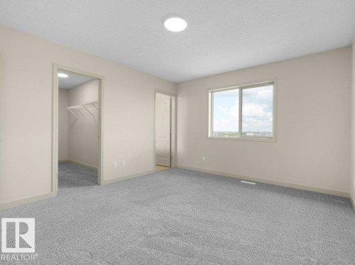 Plush grey carpeting, neutral wall palette, window with natural light, and a built-in wire shelving system in the closet - 3010 17A Ave Nw, Edmonton, AB - Indoor Photo Showing Other Room