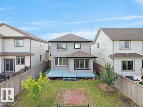 Expansive backyard featuring a manicured lawn, brick patio, and mature trees - 3010 17A Ave Nw, Edmonton, AB - Outdoor