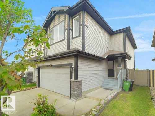 Two-story exterior with light-colored horizontal siding and dark trim accents - 3010 17A Ave Nw, Edmonton, AB - Outdoor