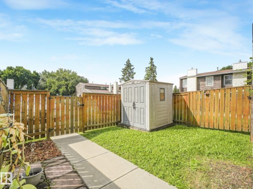 Enclosed backyard featuring a privacy fence, concrete pathway, and a storage shed - 18417 66 Avenue Nw, Edmonton, AB - Outdoor