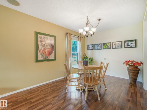 Wood-finish flooring with a multi-tone pattern - 18417 66 Avenue Nw, Edmonton, AB - Indoor Photo Showing Dining Room