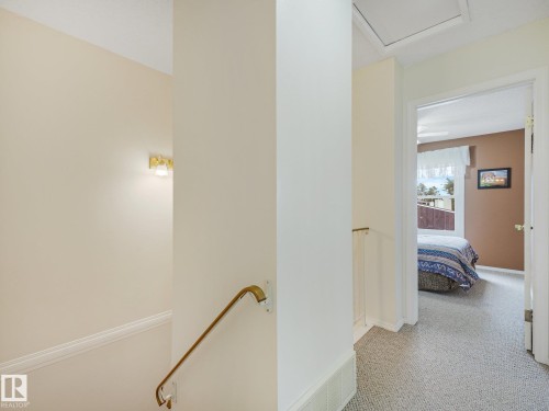 Hallway with light-toned wall paint and carpet flooring - 18417 66 Avenue Nw, Edmonton, AB - Indoor Photo Showing Other Room