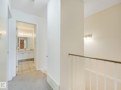 Hallway featuring carpeted flooring and wall-mounted lighting - 18417 66 Avenue Nw, Edmonton, AB - Indoor Photo Showing Other Room