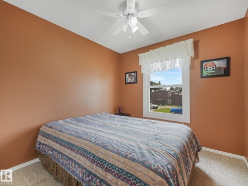 Single-pane window, white ceiling fan, and carpeted flooring - 18417 66 Avenue Nw, Edmonton, AB - Indoor Photo Showing Bedroom