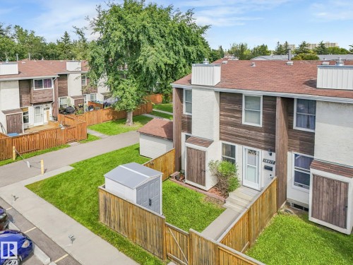 Townhome featuring a private fenced yard with mature landscaping, manicured lawn, and concrete patio - 18417 66 Avenue Nw, Edmonton, AB - Outdoor