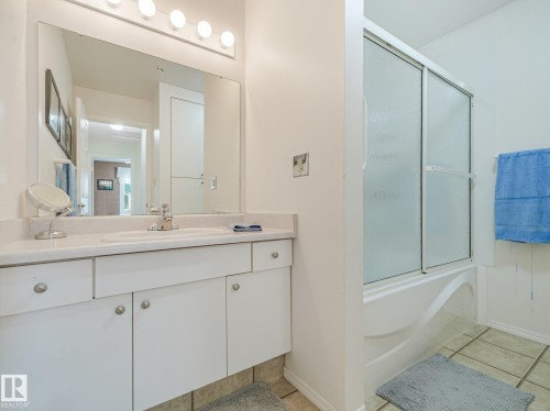 White vanity with chrome faucet and integrated sink - 18417 66 Avenue Nw, Edmonton, AB - Indoor Photo Showing Bathroom