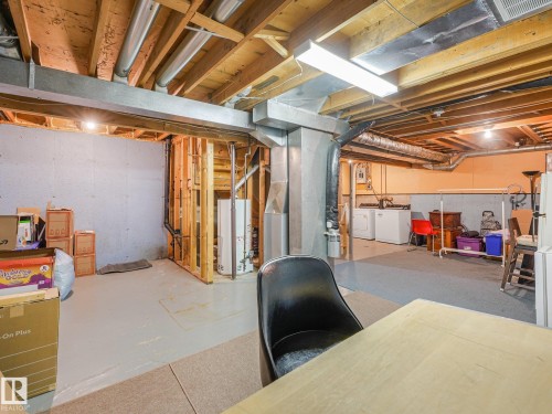 Unfinished basement featuring exposed wood joists, concrete foundation walls, framed wall sections, and overhead fluorescent lighting - 18417 66 Avenue Nw, Edmonton, AB - Indoor Photo Showing Basement