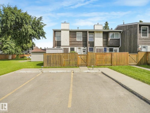 Townhome exterior featuring wood siding and individual private fence - 18417 66 Avenue Nw, Edmonton, AB - Outdoor