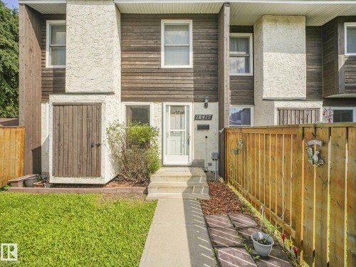 Two-story townhouse exterior featuring wood siding and stucco accents - 18417 66 Avenue Nw, Edmonton, AB - Outdoor