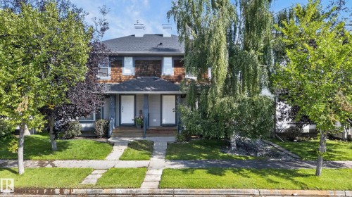 Duplex exterior featuring shingle siding, a dark roof, white entry doors, and a concrete pathway - 6008 South Terwillegar Boulevard Nw, Edmonton, AB - Outdoor