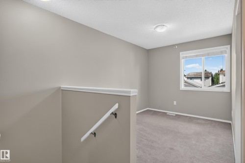 Neutral wall color, carpet flooring, window with white trim, ceiling-mounted lighting, and a white handrail - 6008 South Terwillegar Boulevard Nw, Edmonton, AB - Indoor Photo Showing Other Room