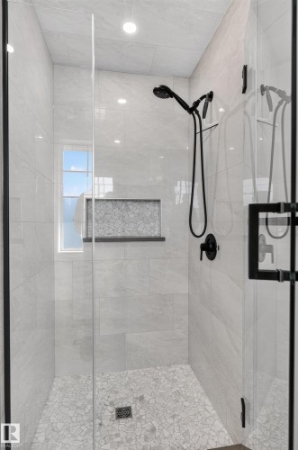Glass-enclosed shower with a matte black shower system, tiled walls, a window, and a mosaic tiled shower pan - 6008 South Terwillegar Boulevard Nw, Edmonton, AB - Indoor Photo Showing Bathroom