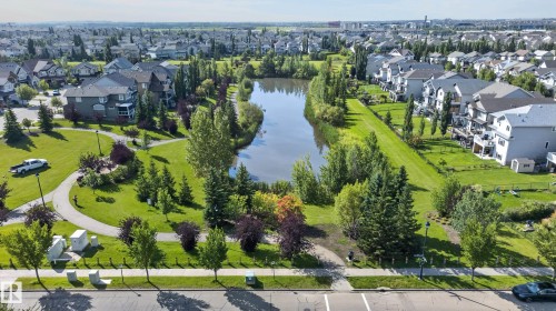 Residential area with a central pond, surrounding green spaces, and paved pathways - 6008 South Terwillegar Boulevard Nw, Edmonton, AB - Outdoor With View