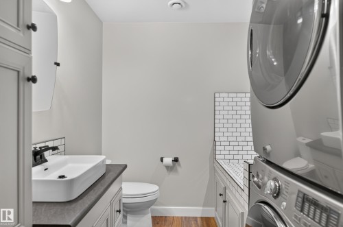 White shaker-style vanity with a vessel sink, matte black faucet, and dark countertop - 6008 South Terwillegar Boulevard Nw, Edmonton, AB - Indoor