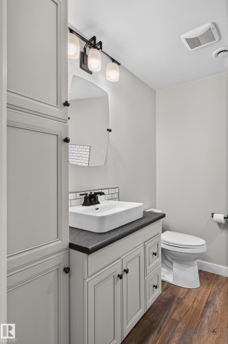 White vanity with shaker-style cabinetry, black countertop, vessel sink, and black wall-mounted faucet - 6008 South Terwillegar Boulevard Nw, Edmonton, AB - Indoor Photo Showing Bathroom