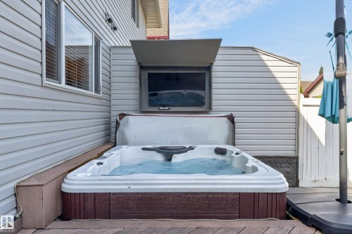 Private deck featuring a hot tub, outdoor television, and siding exterior - 6008 South Terwillegar Boulevard Nw, Edmonton, AB - Outdoor With Exterior