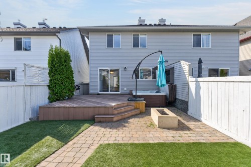 Expansive backyard featuring a wood-finish deck with stairs, a built-in hot tub, and a paver patio with a fire pit - 6008 South Terwillegar Boulevard Nw, Edmonton, AB - Outdoor With Deck Patio Veranda With Exterior