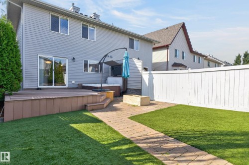 Spacious backyard featuring a composite deck, sliding glass door access, paved pathway, and artificial turf - 6008 South Terwillegar Boulevard Nw, Edmonton, AB - Outdoor