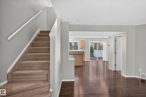 Carpeted staircase with white trim, wood-finish flooring, recessed lighting, and a sliding glass door to the exterior - 6008 South Terwillegar Boulevard Nw, Edmonton, AB - Indoor Photo Showing Other Room