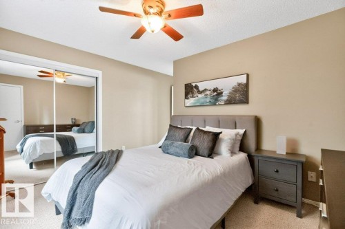 Room featuring a ceiling fan, mirrored closet doors, and carpeted flooring - #201 10528 77 Av Nw, Edmonton, AB - Indoor Photo Showing Bedroom