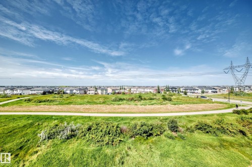 Expansive green space with walking path and residential homes in the background - #401 5390 Chappelle Rd Sw, Edmonton, AB 