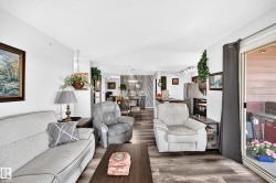 Open-concept living area featuring wood-finish flooring, recessed lighting, and a sliding glass door - 