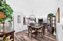 Wood-finish flooring throughout, with a crystal chandelier, and a black countertop bar - 
