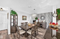 Wood-finish flooring throughout, a geometric accent wall, and a crystal chandelier - 
