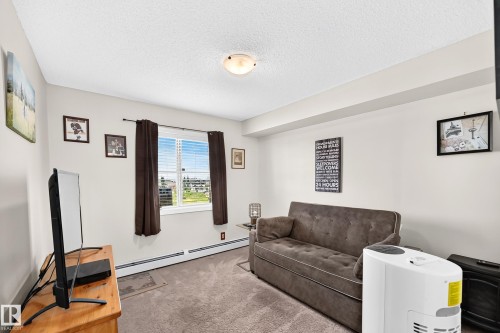 Recessed window with blinds, wall-to-wall carpeting, and baseboard heating - #401 5390 Chappelle Rd Sw, Edmonton, AB 