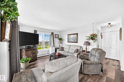 Hardwood-style flooring, white walls, and a window with horizontal blinds - #401 5390 Chappelle Rd Sw, Edmonton, AB 