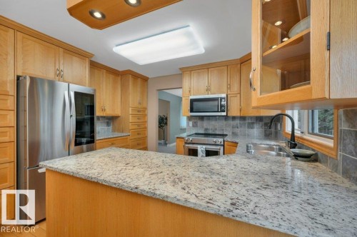 With stainless steel appliances - 5620 151 Street Nw, Edmonton, AB - Indoor Photo Showing Kitchen With Double Sink With Upgraded Kitchen