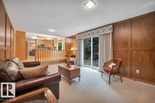 Wall paneling and sliding patio doors onto the large deck - 5620 151 Street Nw, Edmonton, AB - Indoor Photo Showing Living Room