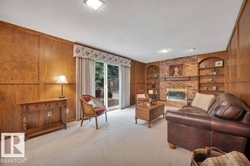 With a gas fireplace with brick facing and book shelves on either side. - 5620 151 Street Nw, Edmonton, AB - Indoor Photo Showing Living Room With Fireplace