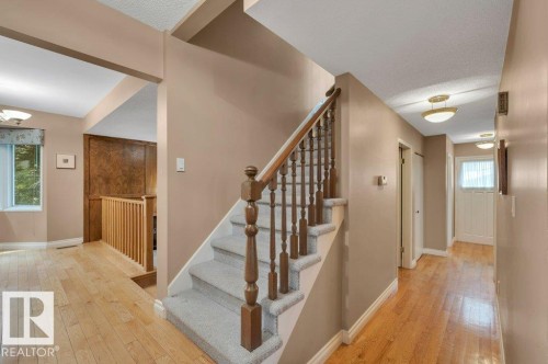 Carpeted staircase with wooden banister and spindles leading to the three bedrooms upstairs. - 5620 151 Street Nw, Edmonton, AB - Indoor Photo Showing Other Room