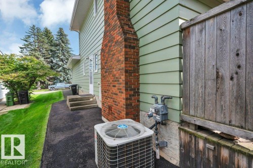 Showing a brick fireplace and A/C unit - 5620 151 Street Nw, Edmonton, AB - Outdoor With Exterior