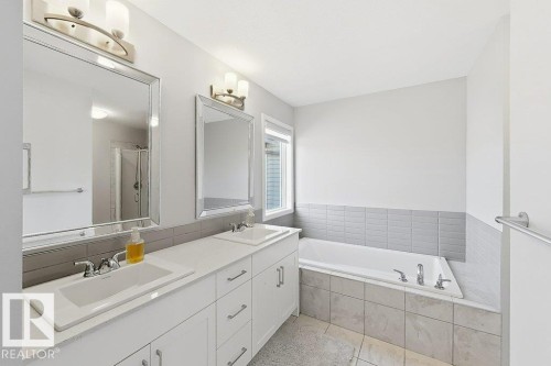 Dual vanity with under-mount sinks, tile flooring, built-in bathtub, and a separate shower enclosure - 4242 Chichak Close Sw, Edmonton, AB - Indoor Photo Showing Bathroom