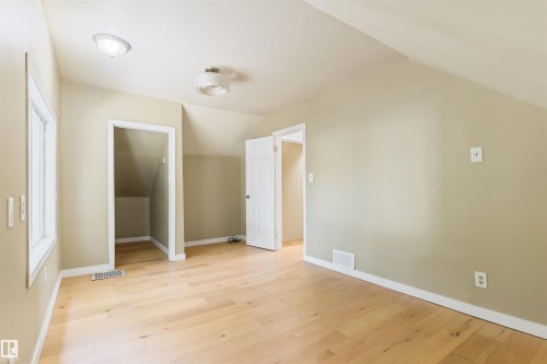 Wood-finish flooring, recessed lighting, sloped ceiling, and multiple doorways - 12337 128 Avenue Nw, Edmonton, AB - Indoor Photo Showing Other Room