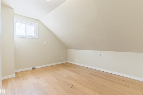 Light wood-finish flooring, white trim, and a window with white casing - 12337 128 Avenue Nw, Edmonton, AB - Indoor Photo Showing Other Room