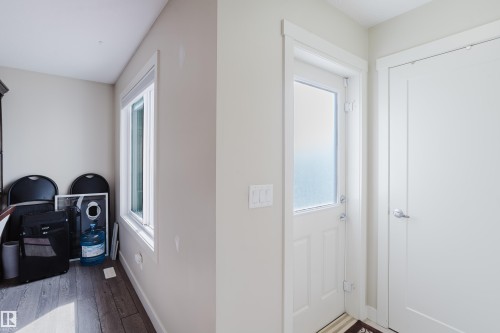Entryway featuring a white door with frosted glass panel, contemporary interior door, light-colored walls, and wood-finish flooring - 124 Cy Becker Boulevard Nw, Edmonton, AB - Indoor Photo Showing Other Room