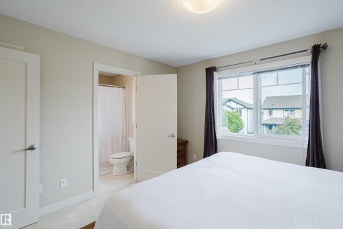 Bright bedroom featuring a large window, neutral wall tones, and carpet flooring - 124 Cy Becker Boulevard Nw, Edmonton, AB - Indoor Photo Showing Bedroom