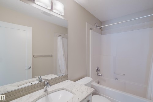 Bathroom featuring a white bathtub and shower combination with a curved shower rod - 124 Cy Becker Boulevard Nw, Edmonton, AB - Indoor Photo Showing Bathroom
