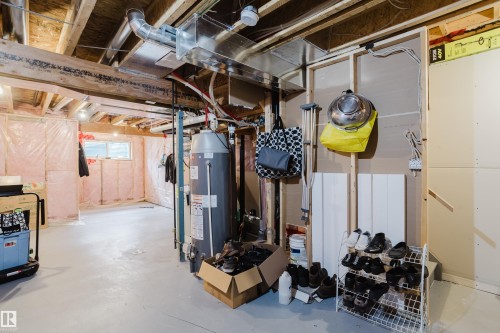 Unfinished lower level featuring exposed wood joists, ductwork, and a water heater - 124 Cy Becker Boulevard Nw, Edmonton, AB - Indoor Photo Showing Basement