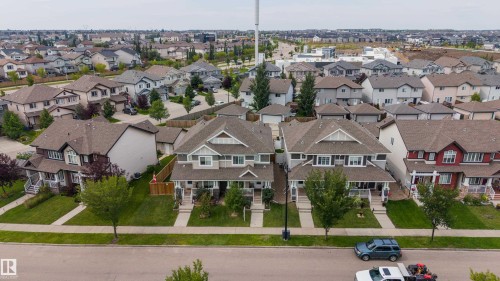 Residential street with established homes, paved sidewalks, and green lawns - 124 Cy Becker Boulevard Nw, Edmonton, AB - Outdoor With Facade