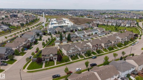 Aerial view of a prestigious residential community featuring elegant architectural design with distinctive rooflines, mature landscaping throughout the neighborhood, manicured lawns, and tree-lined streets - 124 Cy Becker Boulevard Nw, Edmonton, AB - Outdoor With View