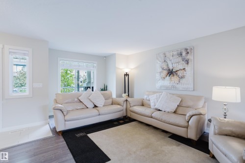 Living area featuring light gray wall paint, wood-finish flooring, and white trim - 124 Cy Becker Boulevard Nw, Edmonton, AB - Indoor Photo Showing Living Room