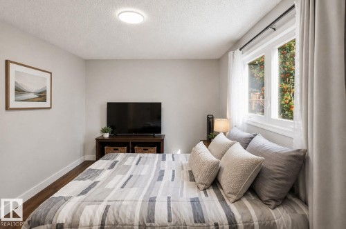 Wood-finish flooring, recessed ceiling lighting, light gray wall tones, and a multi-pane window - 3515 20 Ave Nw, Edmonton, AB - Indoor Photo Showing Bedroom