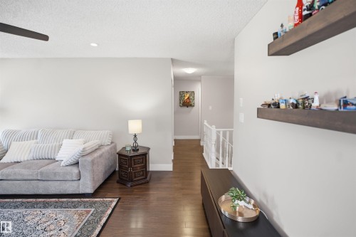 Recessed ceiling lighting, dark wood-finish flooring, white wall paint, and white stair railing - 3515 20 Ave Nw, Edmonton, AB - Indoor Photo Showing Other Room