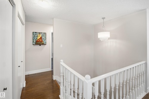Wood-finish flooring with white trim, white paneled doors, and a decorative white chandelier - 3515 20 Ave Nw, Edmonton, AB - Indoor Photo Showing Other Room
