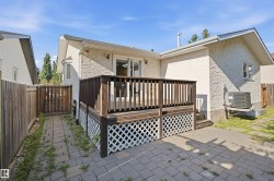 Wood deck with lattice skirting, paver patio, stucco exterior, and bay window - 